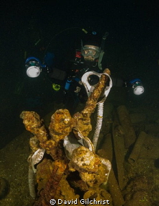 Artifacts of War. Diver prepares to photograph items on w... by David Gilchrist 